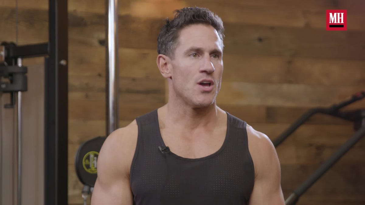 trained man's legs with muscular calves in sneakers in fitness training gym