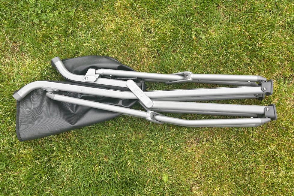 Folded camping chair on grass.