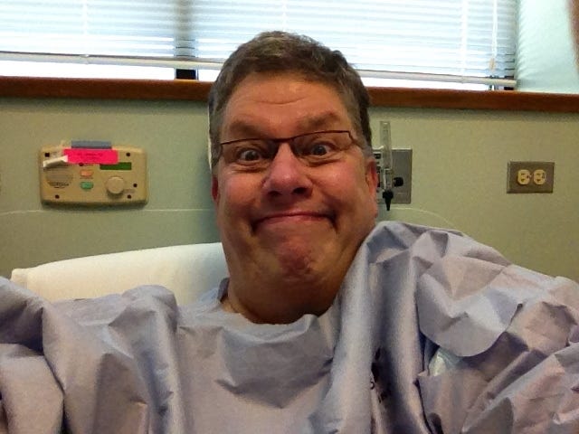 Glen Wagner smiling in a hospital gown before surgery