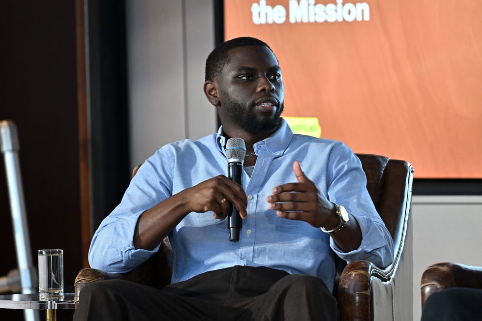 Person speaking into a microphone during a discussion panel. Person speaking into a microphone during a discussion panel.