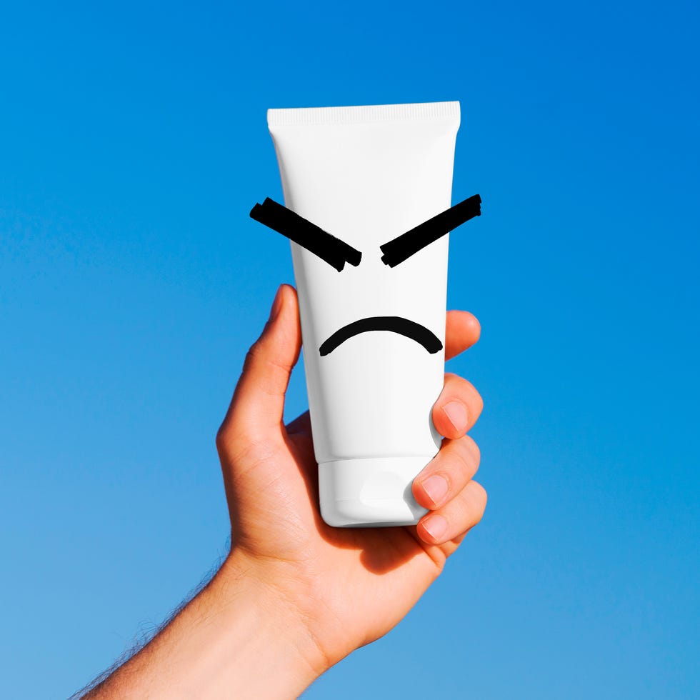 a man's hand holds a white mockup tube of cream on a blue sky background concept of natural cosmetics for skin, shaving, showering, moisturizing and protecting skin