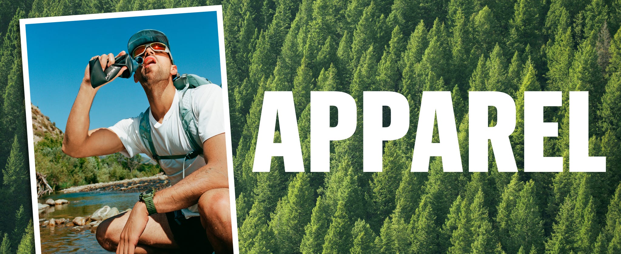 Young man enjoying a drink outdoors while wearing performance apparel, surrounded by nature and trees.