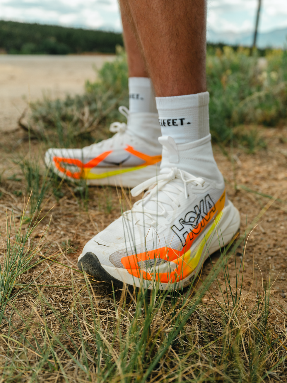 Close-up of athletic shoes with vibrant orange and yellow accents, set against a natural outdoor background. Close-up of athletic shoes with vibrant orange and yellow accents, set against a natural outdoor background.