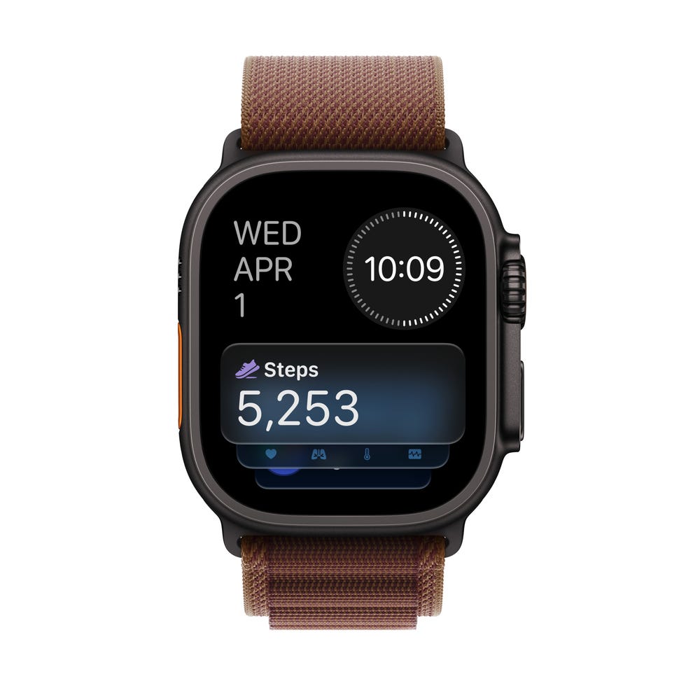 Smartwatch displaying date, time, and step count of 5,253 with a brown woven band.
