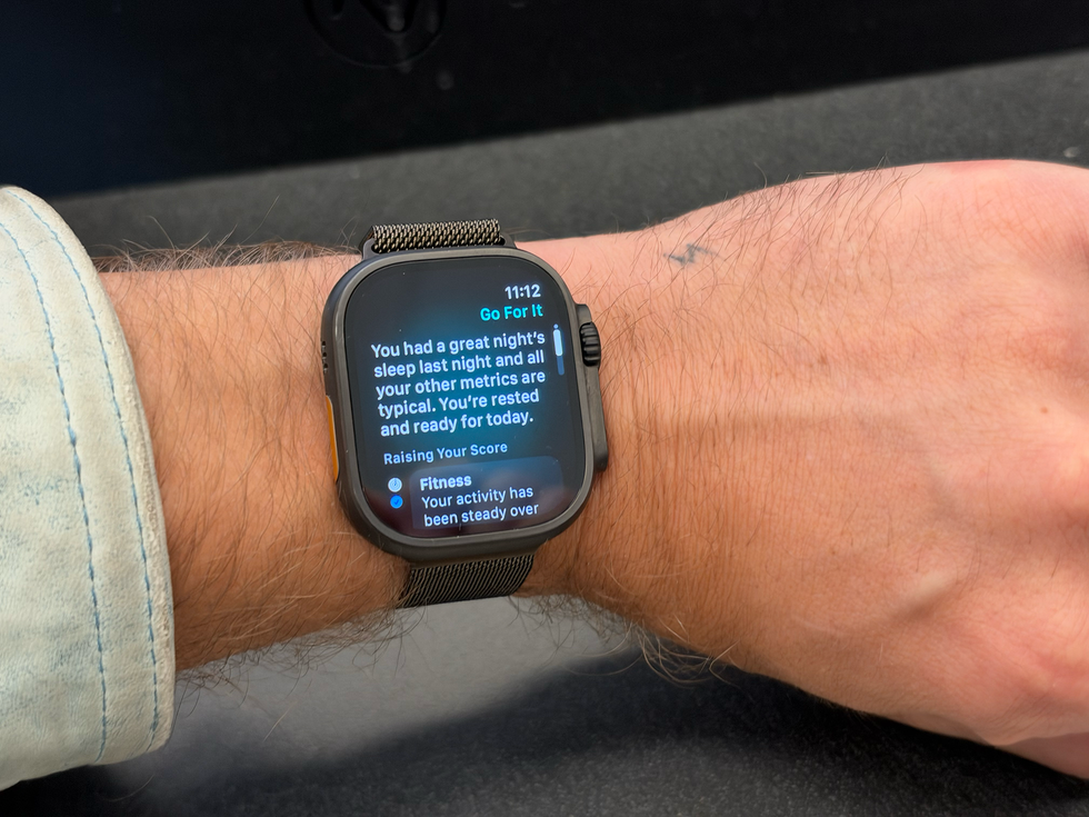 Smartwatch displaying fitness metrics and sleep analysis on a person's wrist.