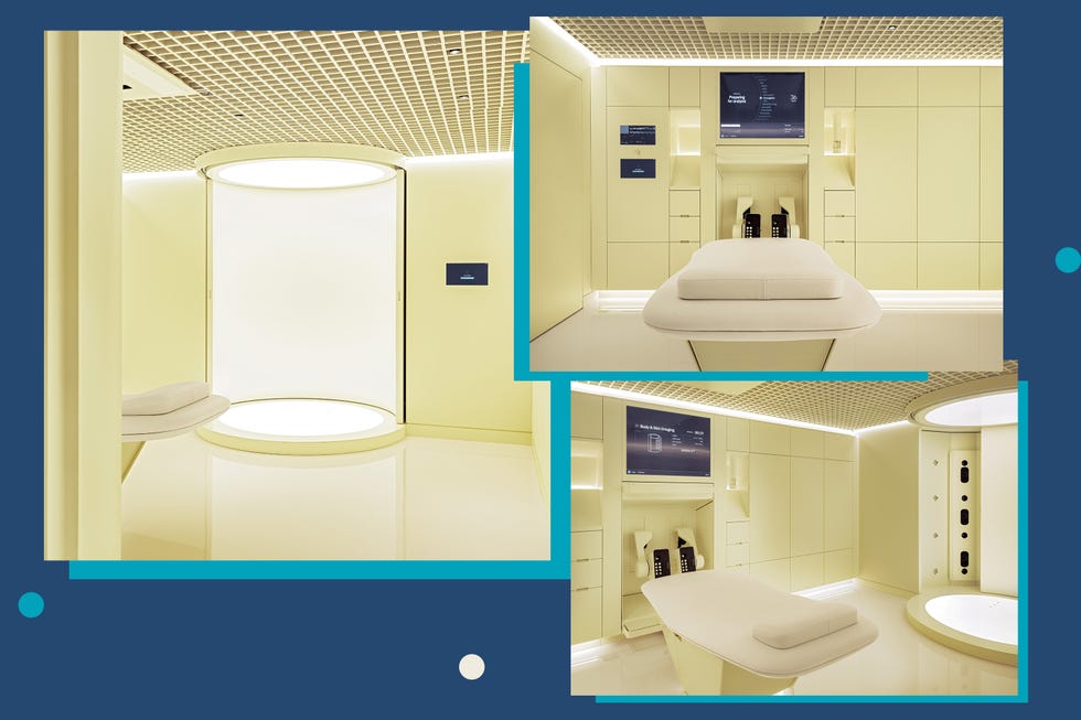 A modern, minimalist wellness room featuring a treatment bed and advanced technology displays.